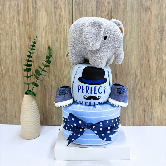 Decorative diaper cake with elephant toy, baby shoes, and a light blue 'Perfect Gentleman' short sleeved baby onesie