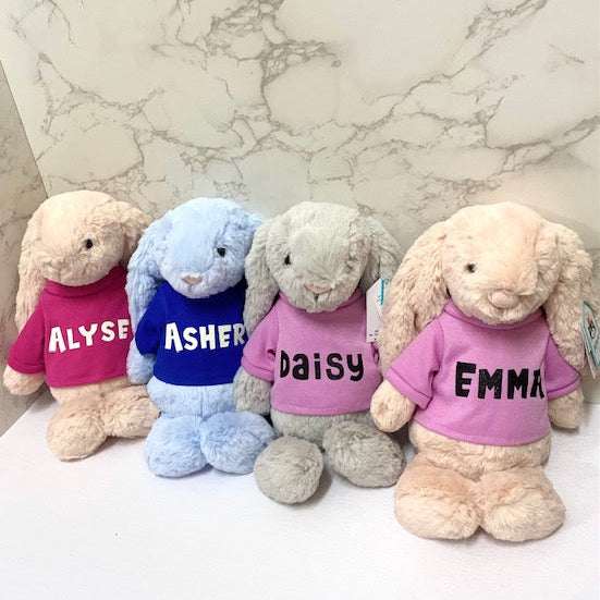 Personalized Jellycat bunnies wearing name shirts on a marble background